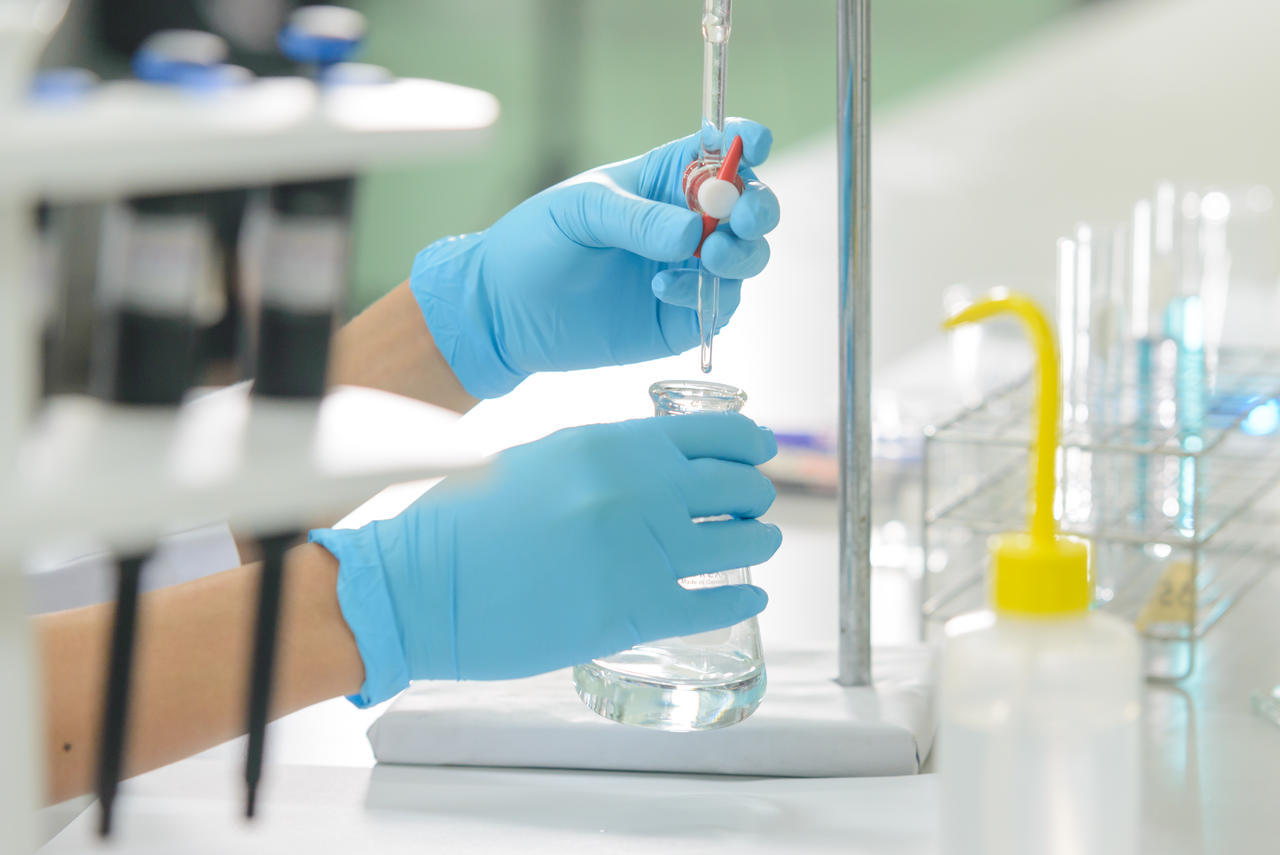 Lab technician inspecting a sample bottle during a quality control check